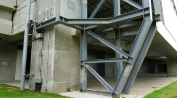 Selective,Focus,Structure,Steel,Beams,,Bars,Beside,Building.,Green,Lawn
