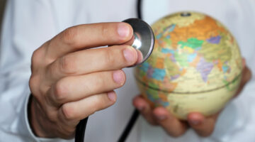 Doctor,With,Stethoscope,And,Globe,In,His,Hand.,Medical,Network