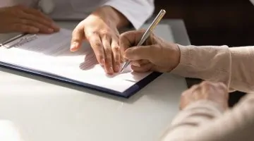Hands,Of,Woman,Filling,Document,At,Appointment,In,Doctor,Office.