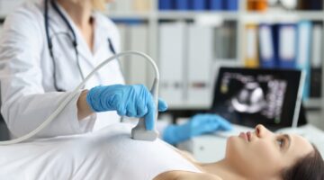 Doctor,Holds,Ultrasound,Probe,On,Chest,Of,Patient,In,Clinic