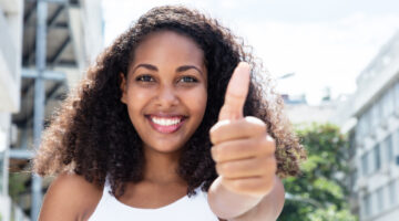 Young,Caribbean,Woman,With,Curly,Hair,In,The,City,Showing