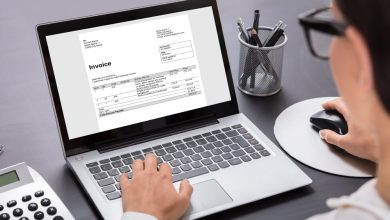 Close-up,Of,A,Businesswoman,Calculating,Invoice,On,Laptop,In,Office