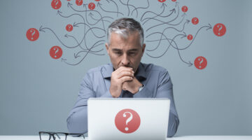 Pensive,Businessman,Sitting,At,Desk,And,Working,With,A,Laptop,